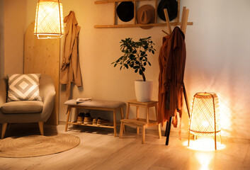 Interior of dark hallway with armchair, bench and glowing lamps