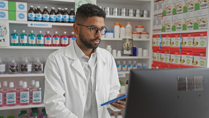 A young african american man dressed as a pharmacist works in an indoor pharmacy store setting.