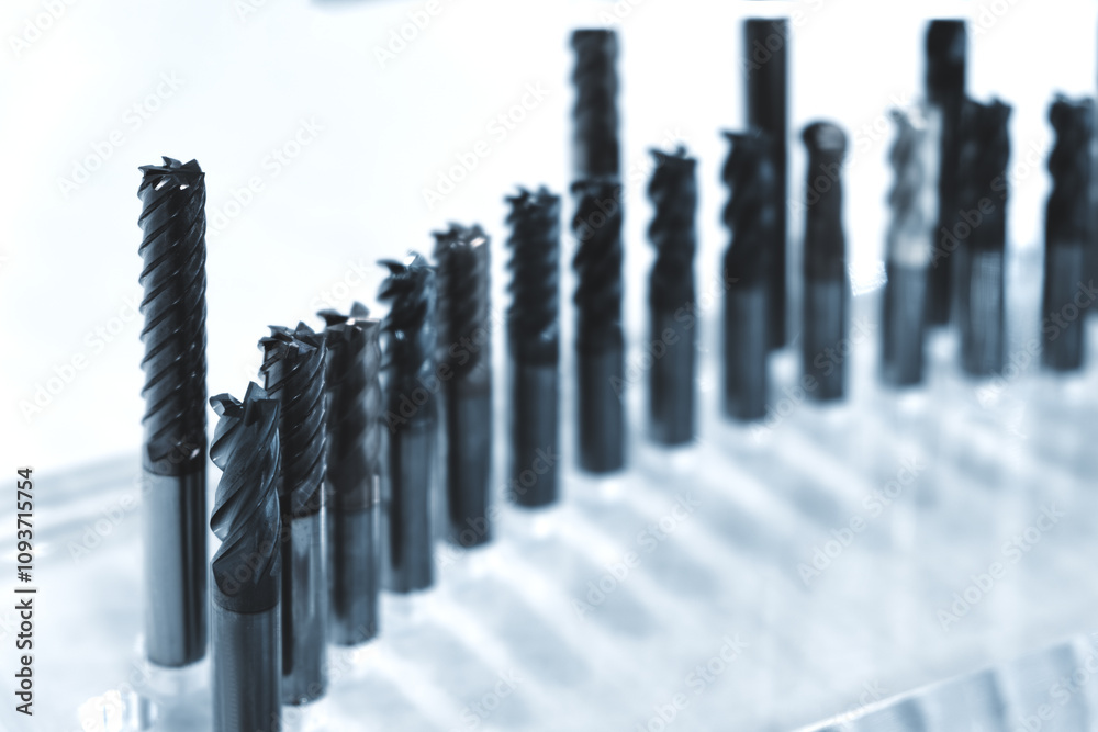 Poster A row of metal tools are on a table. The tools are all different sizes and shapes. Some of the tools are long and thin, while others are short and wide