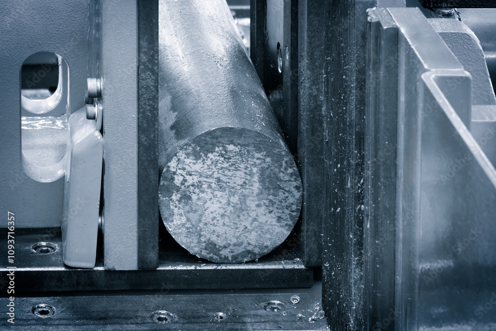 Aufkleber a machine is cutting a metal object. the machine is black and silver. the object being cut is round,