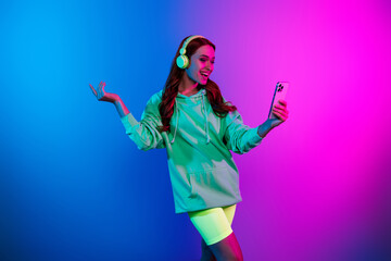 Photo of adorable lovely girl wear green hoodie headphones video call modern device empty space isolated pink light color background