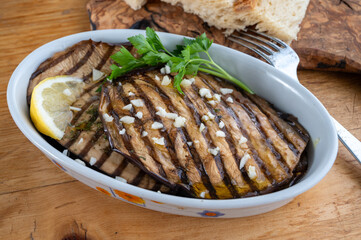 Italian style starter served in restaurant, grilled eggplant with garlic, olive oil and fresh parsley