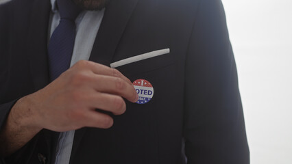 A young man attaches a 'voted' sticker on his suit in an american electoral setting
