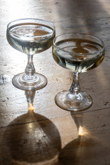 Sparkling wine, cava or champagne in two coupe glasses on wooden table, French Riviera is summer, France