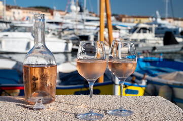 Glasses of cold rose Cote de Provence wine in old fisherman boats and yacht harbour in Saint-Tropez, summer vacation on French Riviera in Provence, France