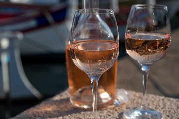 Glasses of cold rose Cote de Provence wine in old fisherman boats and yacht harbour in Saint-Tropez, summer vacation on French Riviera in Provence, France