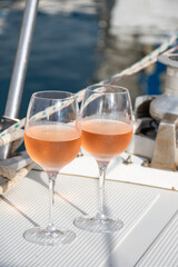Party with rose wine on yacht boat anchored in port la Rague, Gulf of La Napoule, in Provence, two glasses of cold rose wine, French Riviera near Cannes, south of France