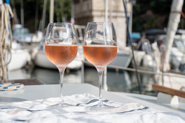 Party with rose wine on yacht boat anchored in port la Rague, Gulf of La Napoule, in Provence, two glasses of cold rose wine, French Riviera near Cannes, south of France