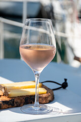 Party with rose wine on yacht boat anchored in port la Rague, Gulf of La Napoule, in Provence, two glasses of cold rose wine, French Riviera near Cannes, south of France
