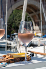 Party with rose wine on yacht boat anchored in port la Rague, Gulf of La Napoule, in Provence, two glasses of cold rose wine, French Riviera near Cannes, south of France