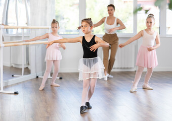 Obraz premium Group of girls dancers rehearsing ballet moves in studio