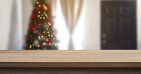 empty wooden table with a living room with a christmas tree in the background