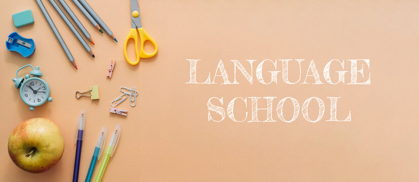 A banner for a language school with a variety of school supplies and a clock