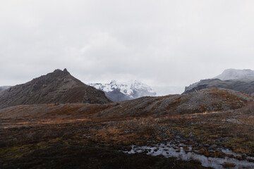 Dramatic landscape showcasing the rugged beauty of iceland with snowy mountain peaks, barren...
