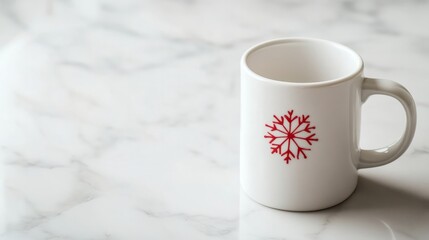 Fototapeta premium A plain white mug with a small red snowflake, placed on a clean marble surface