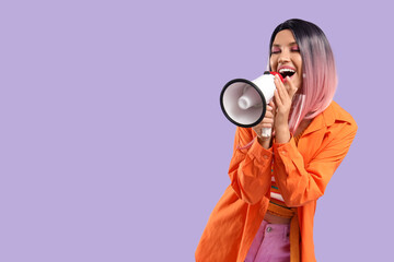 Fototapeta premium Beautiful young happy woman in pink wig with megaphone on purple background
