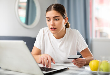 Young woman shopping online with credit card and phone