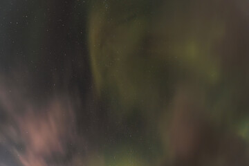 Aurora borealis painting the night sky green and pink, creating a magical spectacle under a starry sky