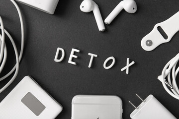 Composition with word DETOX and different modern gadgets on dark background
