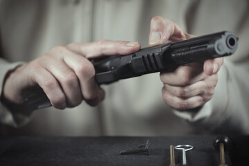 Man take care of semi automatic pistol handgun at home