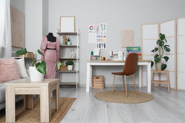 Interior of atelier with tailor's workplace, mannequin and shelf units