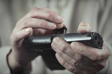 Man take care of semi automatic pistol handgun at home