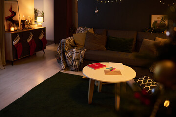 Warm, inviting living room with Christmas decorations, stockings, and fairy lights glowing gently. Wooden table with holiday items, creating a festive atmosphere