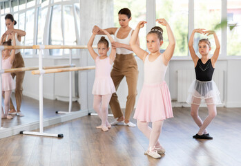 Little girls are learning various dance and ballet movements in the studio © JackF