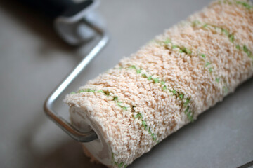 Macro image of a used paint roller with a fluffy and wooly texture.