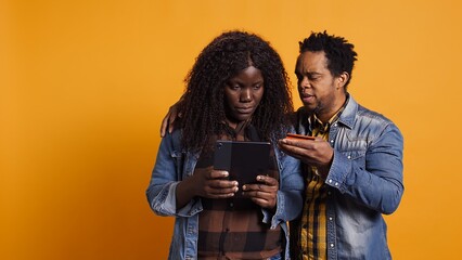African american couple doing online shopping with their card, entering banking numbers and credentials to make electronic payment or paying bills. E commerce purchasing. Camera B.