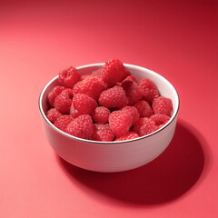 Fresh Raspberry in a bowl on Pastel bright red background