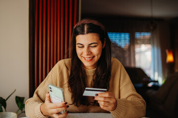 Young caucasian woman buying online on smart phone using credit card	