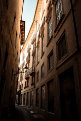 A narrow alleyway between two buildings with window shutters