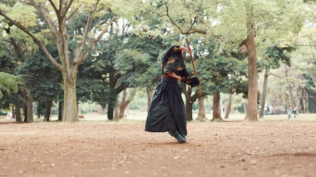 Samurai, forest and woman training in park with sword, self defense and fight exercise outdoor. Tradition, Japanese and fighter with weapon, sport and battle performance of martial arts in Tokyo