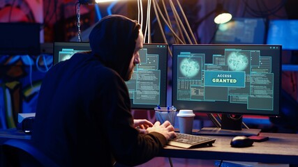 Hacker in hidden base successfully getting past anti tamper measures implemented by companies to protect products. Cracker pirating software and video game releases, camera B