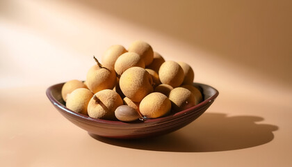 Fresh Longan fruit in a bowl on Pastel light brown background