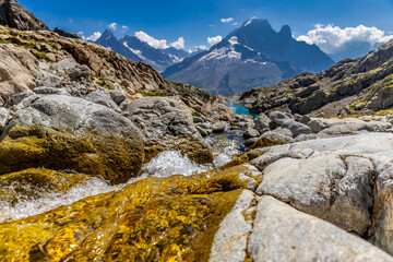 Petit Dru granite mountain wall and summit in Chamonix valley, french Alps. Prominent mountain peak in the Alps, stunning landscape view of the rocky peak covered with clouds, snow and ice