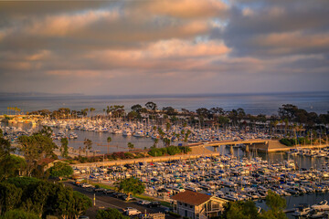 Fototapeta premium Sunset over luxury homes, yachts, and boats in Dana Point harbor, Orange County in Southern California on a cloudy day