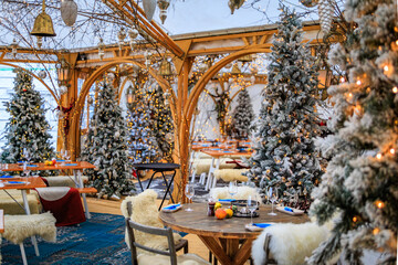 Rustic winter wonderland: wooden tables, cozy fur throws, Christmas trees and festive touches await diners at a restaurant in Zurich, Switzerland