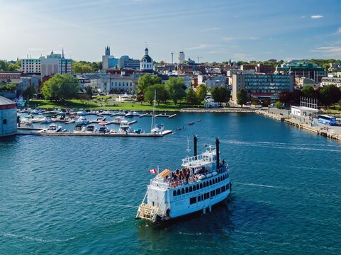 Ferry docking on the Riverfront of the St Lawrence River in Downtown Kingston. In the background is the Kingston City Hall. Ontario, Canada.