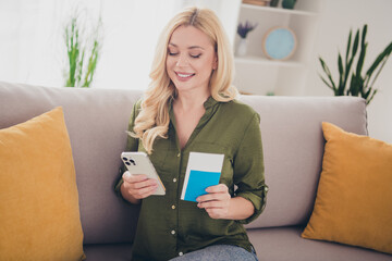 Photo of lovely adorable woman preparing flight booking hotel sitting sofa indoors flat weekend...