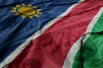 waving colorful flag of namibia on the dollar money background. finance concept.