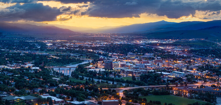 Missoula Montana with the clark fork river at sunset with glowing city lights during blue hour