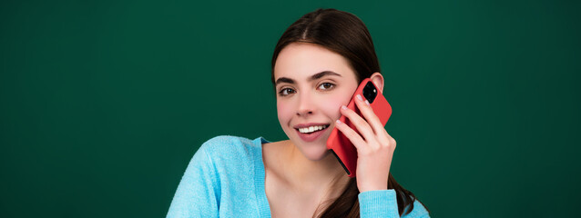 Female student using phone in classroom. School girl chatting on mobile phone near blackboard. Education concept. Lesson and homework in high school.