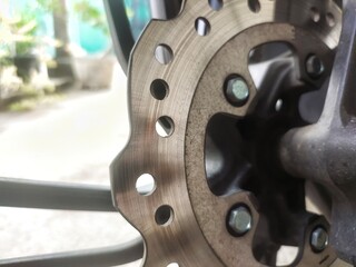 Closeup of a disc on the front wheel of a motorcycle. Disc brakes are braking systems designed to...