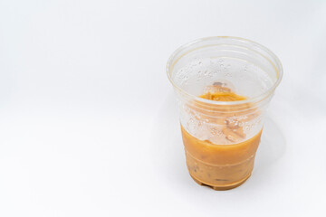 Iced caramel macchiato in a plastic cup, showing the beautiful swirls of coffee, milk, and caramel isolated