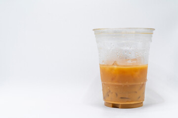 Iced caramel macchiato in a plastic cup, showing the beautiful swirls of coffee, milk, and caramel isolated