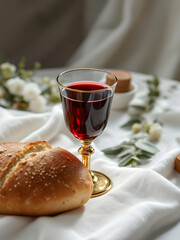 A communion setup with a chalice of wine, a loaf of bread, and a white cloth, symbolizing faith and tradition.