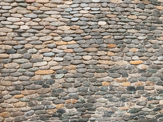 A wall made of stone blocks with a brown and gray color