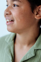 Joyful young boy with bright smile brushing teeth in close up view